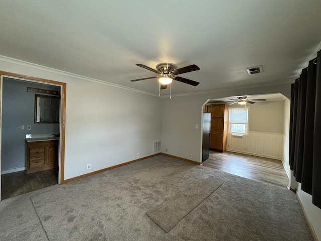 carpeted spare room with crown molding and ceiling fan