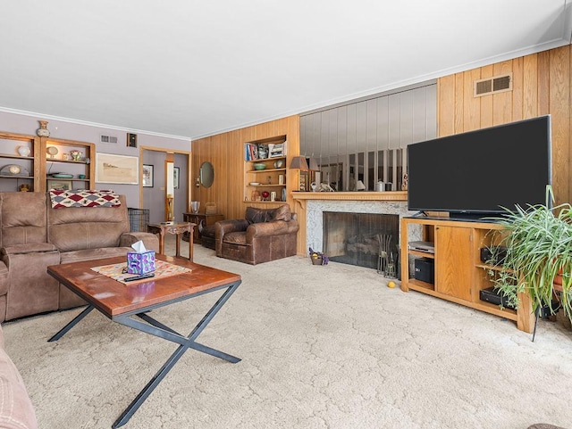 carpeted living room featuring crown molding and wooden walls