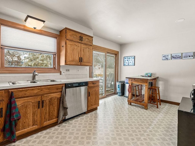 kitchen featuring stainless steel dishwasher, sink, and a wealth of natural light