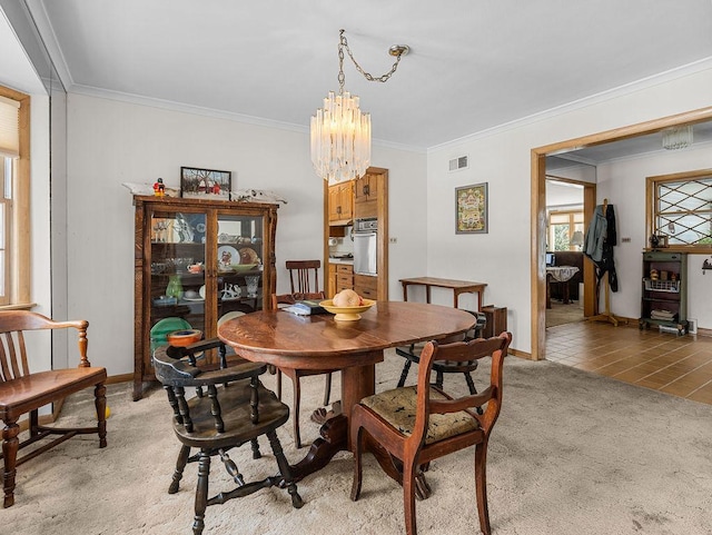 dining room with crown molding, carpet, and a notable chandelier