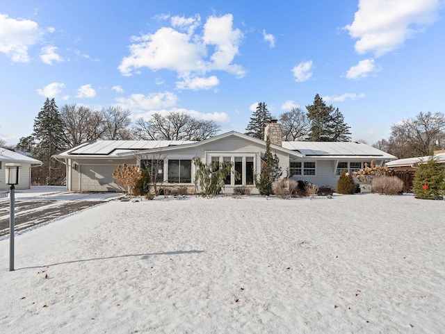 view of front of home featuring a garage and solar panels