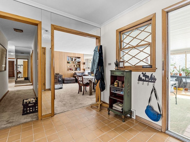 entryway featuring crown molding and light carpet