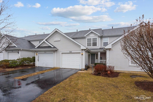 traditional-style house featuring a garage, driveway, and a front yard