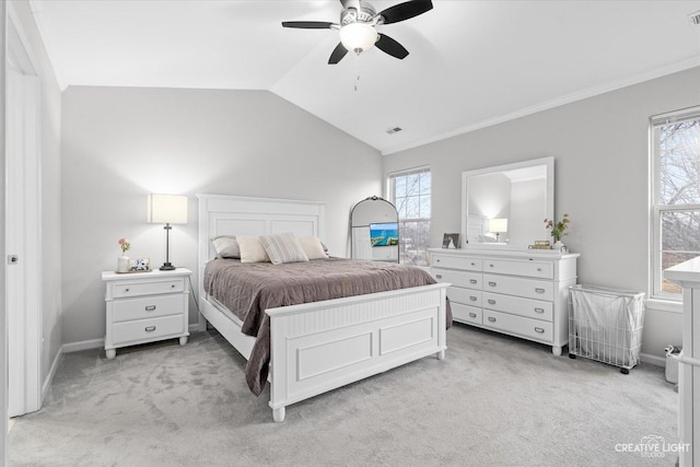 bedroom with lofted ceiling, multiple windows, baseboards, and light colored carpet