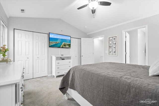 bedroom featuring light carpet, visible vents, lofted ceiling, ceiling fan, and multiple closets