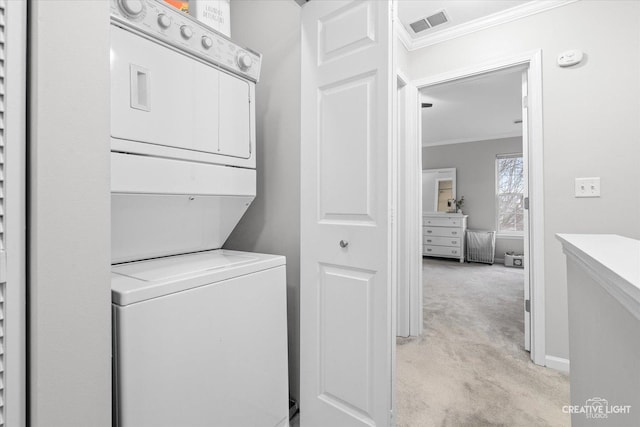 clothes washing area featuring crown molding, visible vents, stacked washer / dryer, light carpet, and laundry area