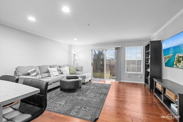 living area featuring baseboards, ornamental molding, wood finished floors, and recessed lighting