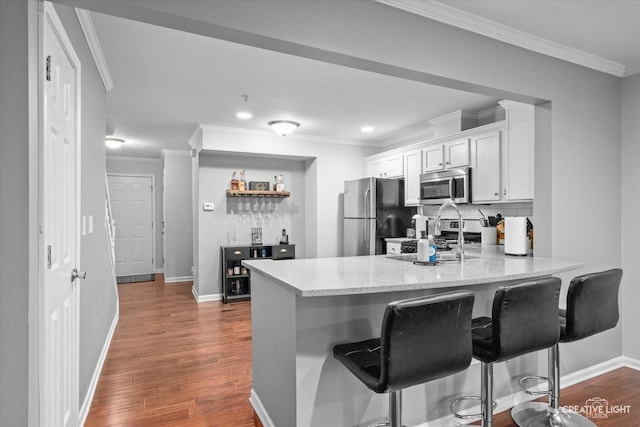 kitchen with stainless steel appliances, dark wood-type flooring, a peninsula, and a kitchen bar