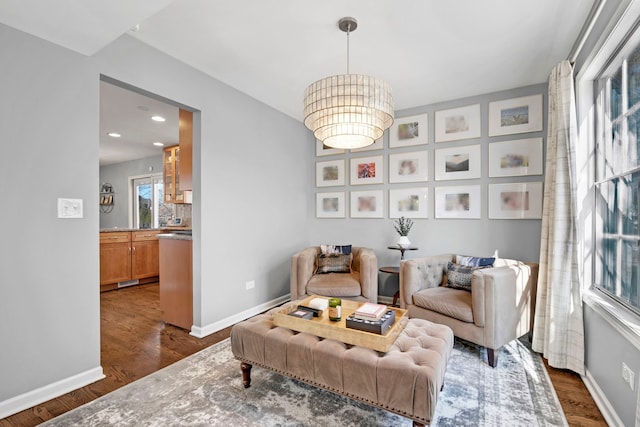 sitting room featuring a notable chandelier and dark hardwood / wood-style floors