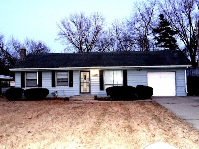 ranch-style house featuring a garage, driveway, and a chimney