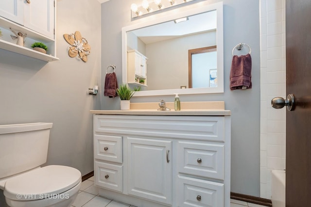 bathroom with toilet, baseboards, vanity, and tile patterned floors