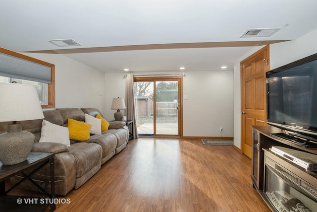 living room with baseboards, recessed lighting, visible vents, and light wood-style floors