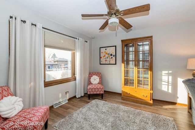 sitting room featuring baseboards, visible vents, and light wood-style floors