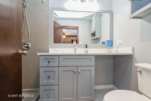 bathroom featuring toilet, vanity, and baseboards