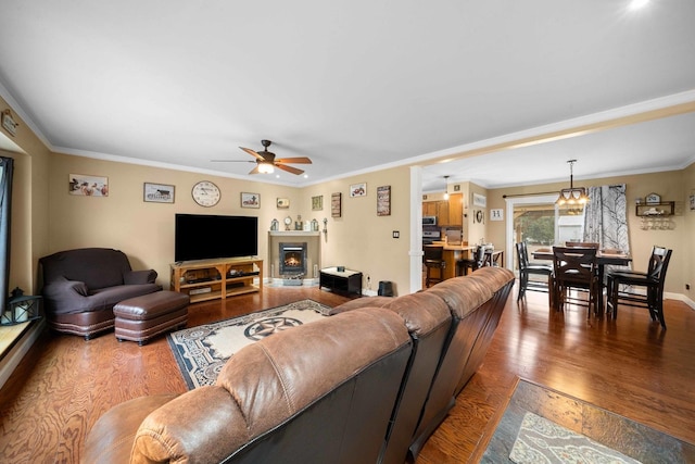 living room with hardwood / wood-style floors, ceiling fan with notable chandelier, and ornamental molding