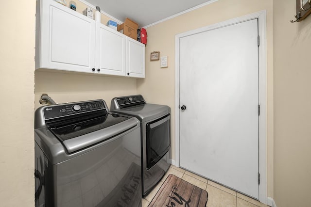 clothes washing area featuring cabinets, washing machine and dryer, light tile patterned floors, and crown molding