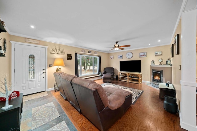 living room with crown molding, wood-type flooring, and ceiling fan