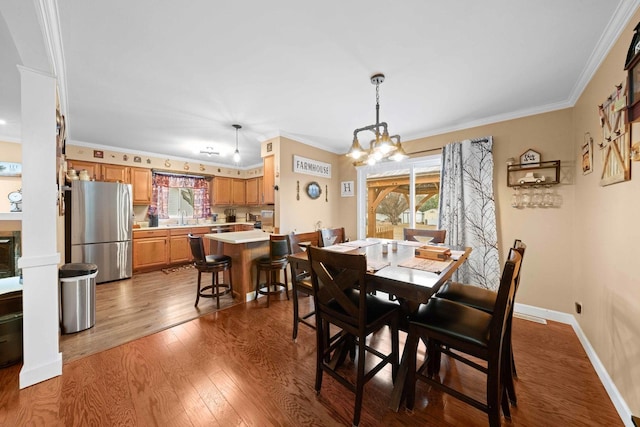 dining area with hardwood / wood-style floors, ornamental molding, sink, and a healthy amount of sunlight