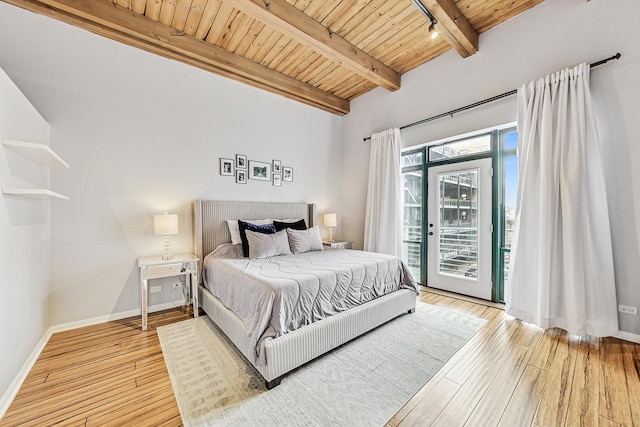 bedroom featuring beamed ceiling, wooden ceiling, light hardwood / wood-style floors, and access to outside