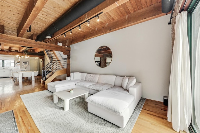 living room featuring beamed ceiling, rail lighting, a chandelier, wooden ceiling, and light wood-type flooring