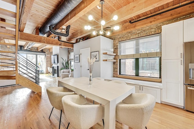 dining area with beamed ceiling, light wood-type flooring, wooden ceiling, and a chandelier