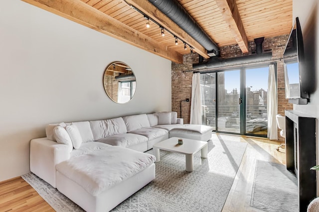 living room with wood ceiling, light hardwood / wood-style flooring, track lighting, brick wall, and beam ceiling