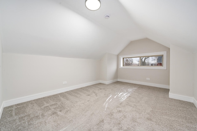 additional living space with carpet floors and vaulted ceiling