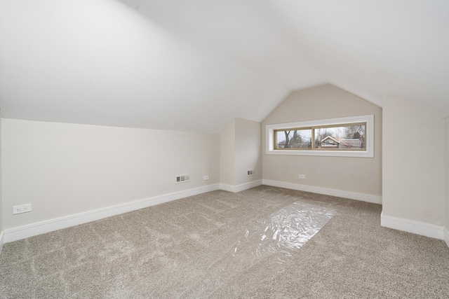 bonus room featuring vaulted ceiling and light carpet