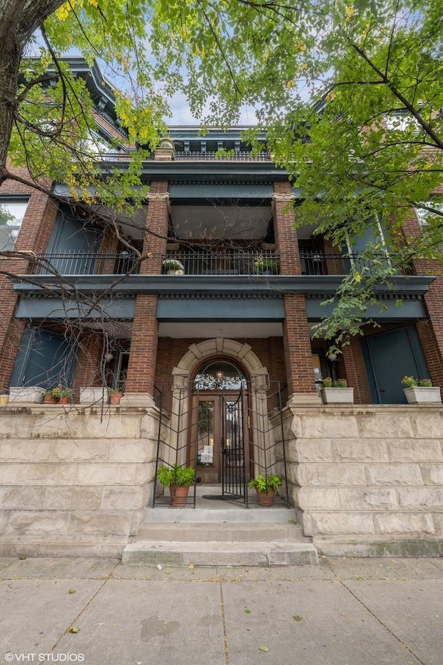 view of exterior entry with a balcony