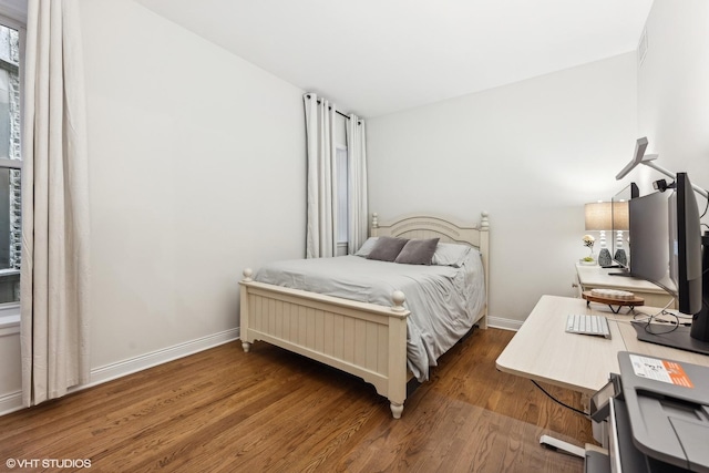 bedroom with dark hardwood / wood-style floors