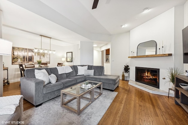 living room featuring ceiling fan with notable chandelier, lofted ceiling, and hardwood / wood-style floors