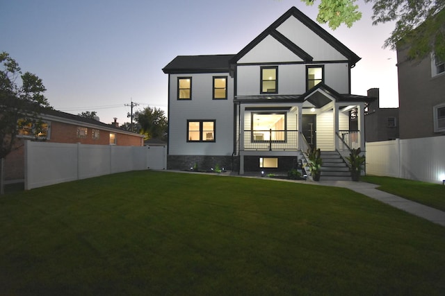 back house at dusk with a yard