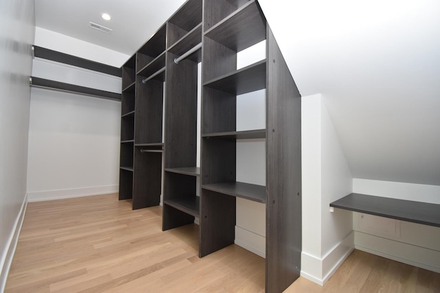 walk in closet with light hardwood / wood-style flooring