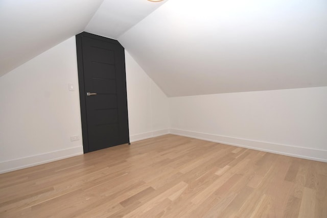 bonus room featuring lofted ceiling and light hardwood / wood-style flooring