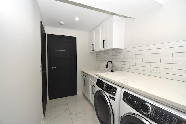 laundry area with cabinets, washing machine and clothes dryer, and sink