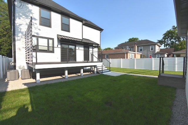 rear view of property featuring a yard, central AC, and a deck