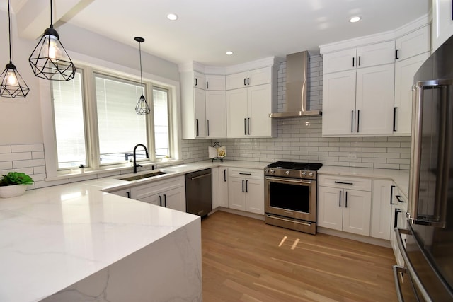 kitchen featuring stainless steel range with gas cooktop, dishwasher, white cabinets, light stone counters, and wall chimney exhaust hood