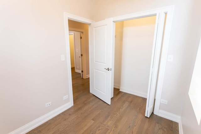 unfurnished bedroom featuring baseboards and wood finished floors