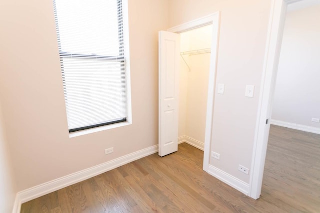 unfurnished bedroom with baseboards and light wood-style floors