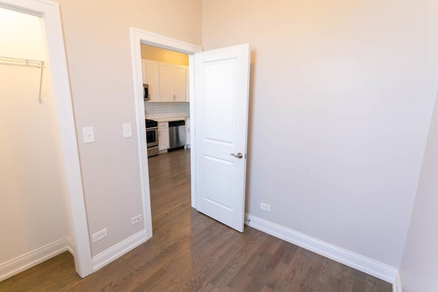 interior space featuring dark wood-style flooring and baseboards