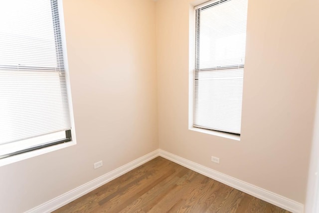 empty room with baseboards and wood finished floors