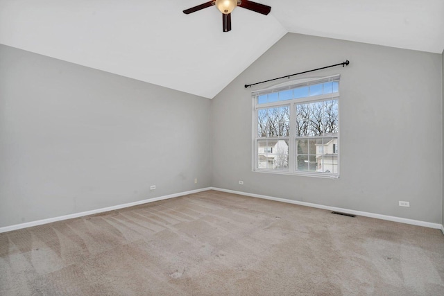 carpeted spare room featuring vaulted ceiling and ceiling fan