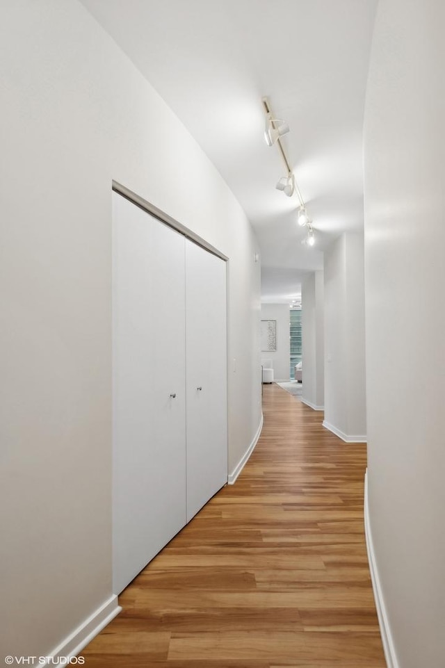 hall featuring track lighting and light hardwood / wood-style floors