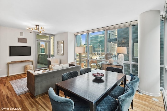 dining space with an inviting chandelier, hardwood / wood-style flooring, and expansive windows