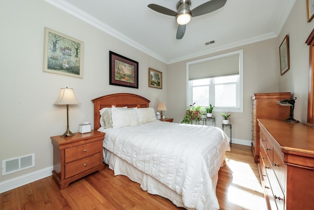 bedroom with light wood-style floors, visible vents, and crown molding