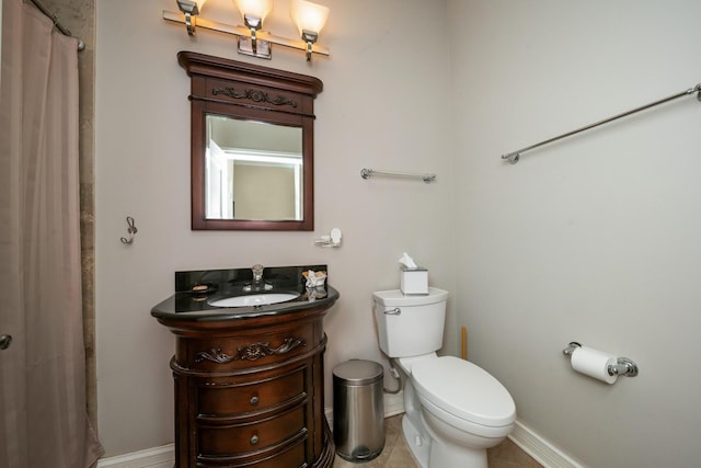 bathroom featuring baseboards, vanity, and toilet