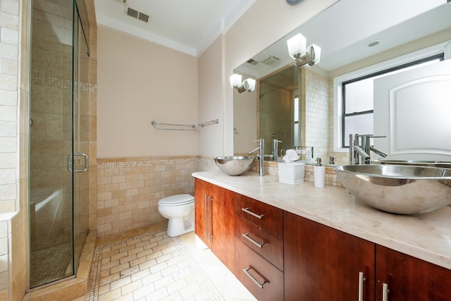 full bath with a stall shower, a sink, visible vents, and tile walls