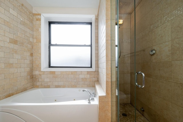 bathroom featuring a jetted tub and a shower stall