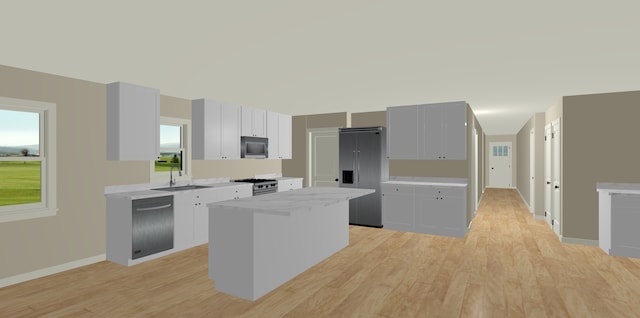 kitchen with sink, white cabinetry, a center island, light wood-type flooring, and premium appliances