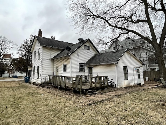 rear view of property featuring a wooden deck and a yard